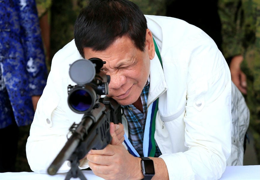 Philippines President Rodrigo Duterte checks the scope of a 7.62mm sniper rifle during the turnover ceremony of China's urgent military assistance.