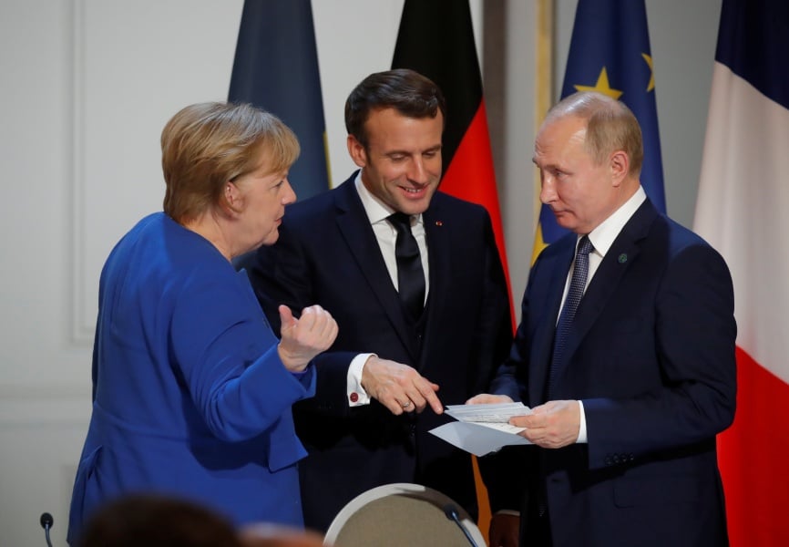 German Chancellor Angela Merkel, French President Emmanuel Macron, and Russian President Vladimir Putin. REUTERS.