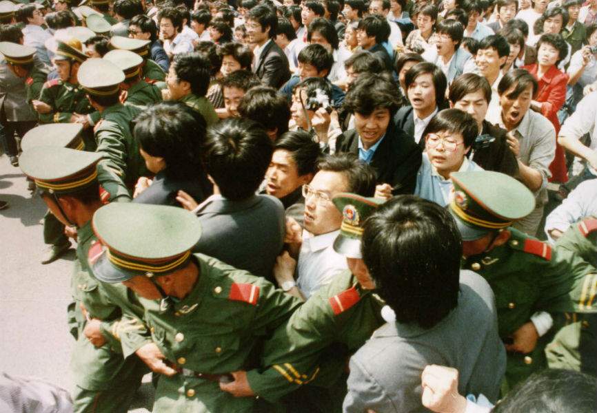 Student protesters push through a police cordon to enter Tiananmen Square on June 4, 1989. REUTERS.