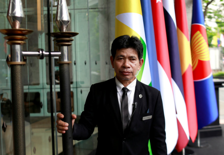 A security officer stands in front of Southeast Asian flags at the 34th ASEAN Summit in Bangkok. REUTERS.