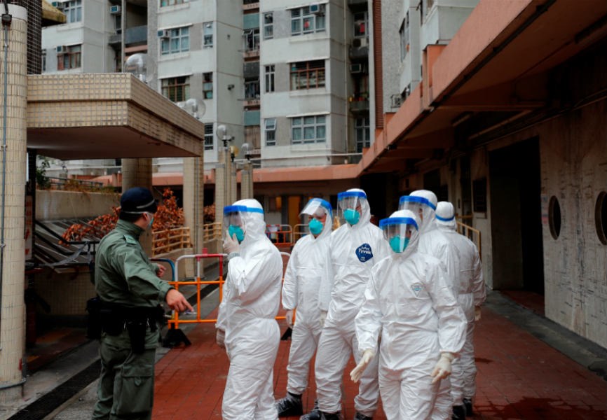 Police wait to evacuate residents from a public housing building in Hong Kong following the coronavirus outbreak. 