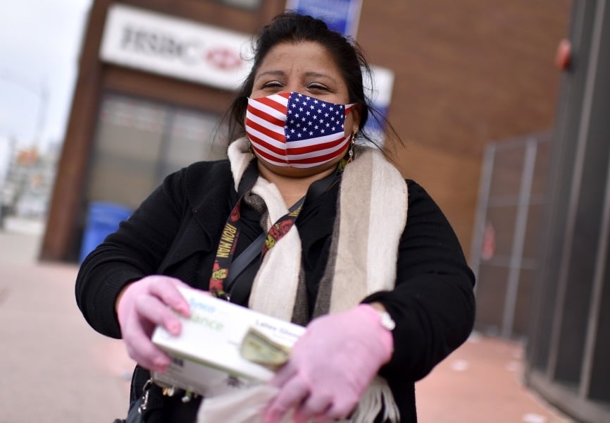 A woman wearing an American flag face mask sells PPE and disinfectant in New York. REUTERS.