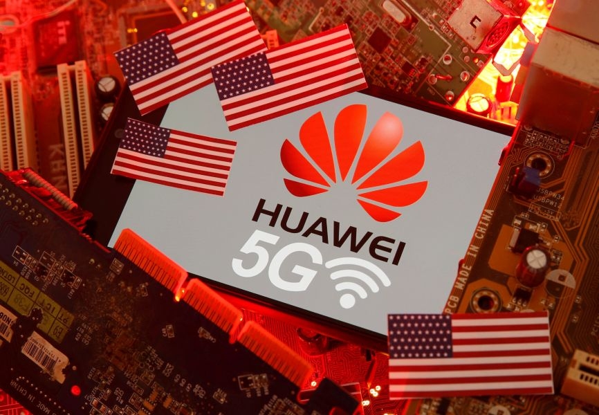 A US flag and a smartphone with the Huawei and 5G logo. REUTERS.