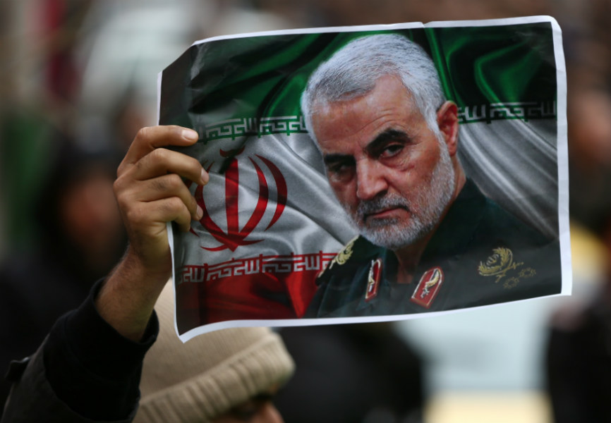An Iranian holds a photo of the late General Qassem Suleimani. REUTERS.